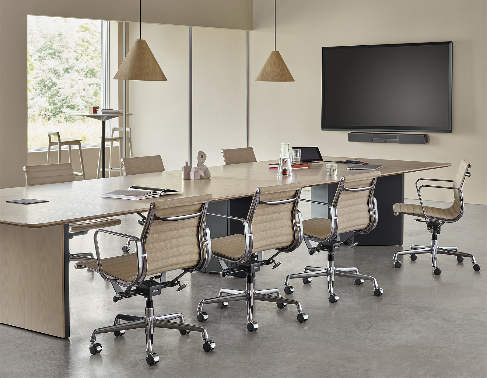 Conference room with table, chairs, hanging light fixture, and tv. Scene has muted colors. Grey floors and beige furniture.